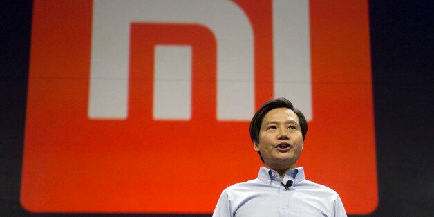 Xiaomi Chairman Lei Jun stands in front of the logo of the Chinese smartphone maker, at a press event in Beijing, Thursday, Jan. 15, 2015. The Chinese manufacturer on Thursday unveiled a new model that Lei said has processor size and performance comparable to Appleâs iPhone 6 but is thinner and lighter. (AP Photo/Ng Han Guan)