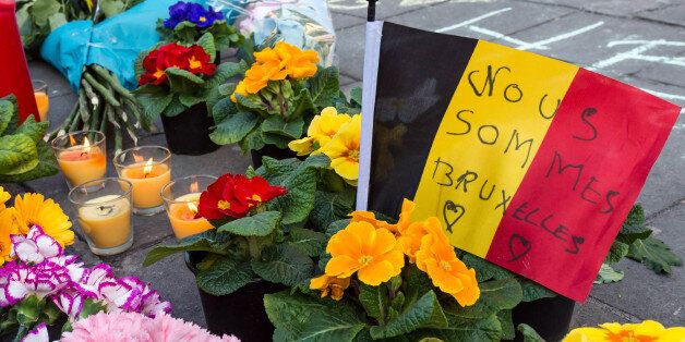 A memorial to attack victims with a Belgian flag and flowers is set up outside the stock exchange in Brussels on Tuesday, March 22, 2016. Explosions, at least one likely caused by a suicide bomber, rocked the Brussels airport and subway system Tuesday, prompting a lockdown of the Belgian capital and heightened security across Europe. (AP Photo/Geert Vanden Wijngaert)