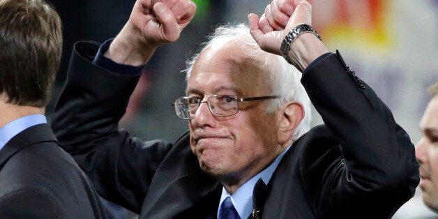 Democratic presidential candidate Sen. Bernie Sanders, I-Vt., pumps his fists as he leaves the field after speaking at a rally Friday, March 25, 2016, in Seattle. (AP Photo/Elaine Thompson)
