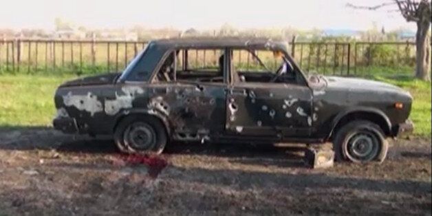 In this image from TV, a car destroyed with blood showing in the aftermath after heavy fighting erupted in Terter, Azerbaijan, Saturday April 2, 2016, between Armenian and Azerbaijani forces over the separatist region of Nagorno-Karabakh.  Russia expressed grave concern on Saturday over the recent military conflict along the Azerbaijan-Armenia border, calling on all parties involved to stop fighting and exercise restraint. Officials from each of the former Soviet republics blamed the other on Sa