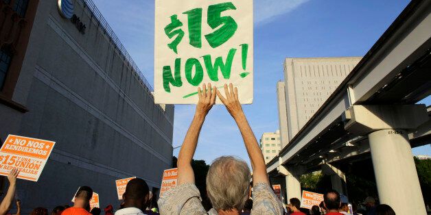 Protestors march in support of raising the minimum wage to $15 an hour as part of an expanding national movement known as Fight for 15, Wednesday, April 15, 2015, in Miami. The event was part of a national protest day to coincide with the April 15 deadline for filing income taxes. (AP Photo/Lynne Sladky)