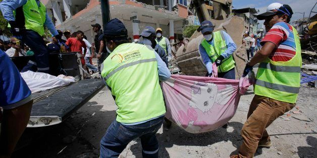 Volunteers carry a body pulled from the rubble in Pedernales, Ecuador, Sunday, April 17, 2016. Rescuers pulled survivors from rubble Sunday after the strongest earthquake to hit Ecuador in decades flattened buildings and buckled highways along its Pacific coast.  (AP Photo/Dolores Ochoa)