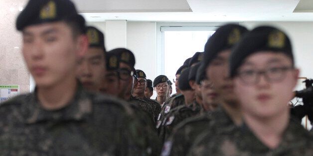 South Korean army soldiers wait to cast their preliminary votes for the upcoming parliamentary election at a local polling station in Seoul, South Korea, Friday, April 8, 2016. The two-day preliminary votes began in the day, and it is the first time that the system is being applied in a nationwide parliamentary election. The rest of the voters go to the polls on April 13. (AP Photo/Ahn Young-joon)