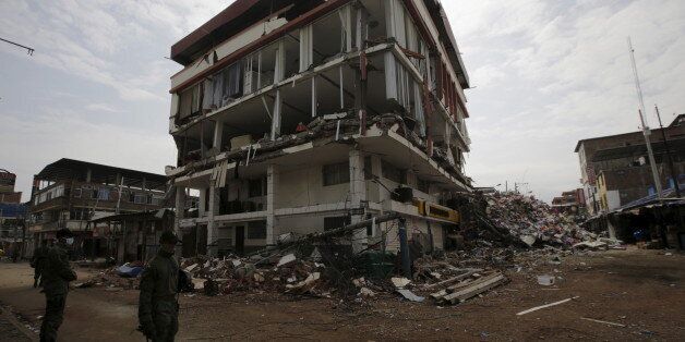 Soldiers stand guard next to a collapsed buildings at the village of Manta, after an earthquake struck off Ecuador's Pacific coast, April 21, 2016. REUTERS/Henry Romero