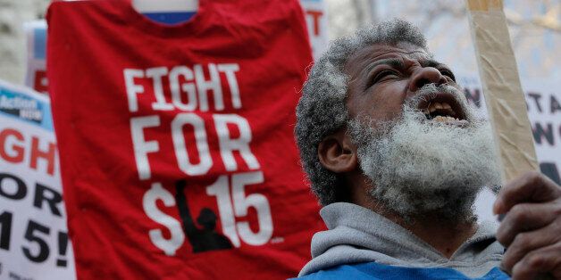 A demonstrator reacts as they gather on the sidewalk with placards during a protest for a $15-an-hour nationwide minimum wage in downtown Chicago, Illinois, April 14, 2016.   REUTERS/Jim Young TPX IMAGES OF THE DAY