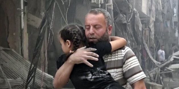 In this image made from video and posted online from Validated UGC, a man carries a child after airstrikes hit Aleppo, Syria, Thursday, April 28, 2016. A Syrian monitoring group and a first-responders team say new airstrikes on the rebel-held part of the contested city of Aleppo have killed over a dozen people and brought down at least one residential building. The new violence on Thursday brings the death toll in the past 24-hours in the deeply divided city to at least 61 killed. (Validated UGC