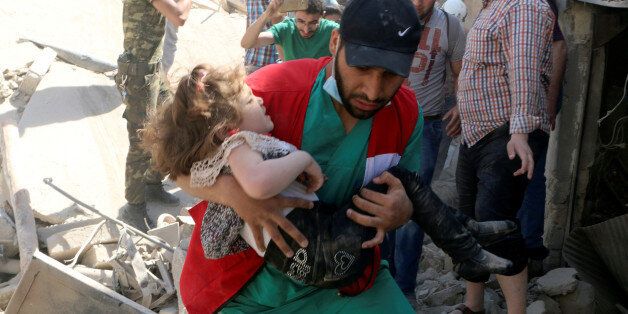 A civil defence member carries a child that survived from under the rubble at a site hit by airstrikes in the rebel held area of Old Aleppo, Syria, April 28, 2016. REUTERS/Abdalrhman Ismail     TPX IMAGES OF THE DAY
