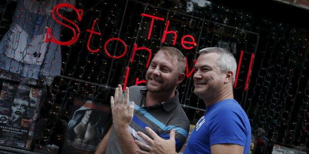 Charles Wooton (R) and Keith Newport, both from Atlanta, Georgia, show their wedding rings outside the Stonewall Inn in the Greenwich Village neighborhood of New York, June 26, 2015, following the announcement that the U.S. Supreme Court had ruled that the U.S. Constitution provides same-sex couples the right to marry in a historic triumph for the American gay rights movement.  REUTERS/Mike Segar