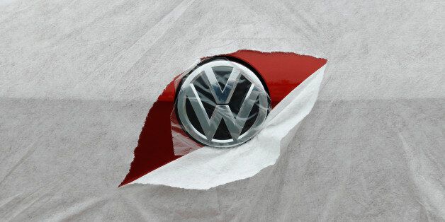 A VW badge is seen through torn wrapping as a Volkswagen Golf is delivered to a car dealership in Portslade near Brighton in southern England April 24, 2013. In the 12 months ending in March, car registrations in Britain rose 7.2 percent compared with the same period a year earlier. REUTERS/Luke MacGregor  (BRITAIN - Tags: TRANSPORT BUSINESS)