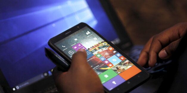 A Microsoft delegate checks applications on a smartphone during the launch of the Windows 10 operating system in Kenya's capital Nairobi, July 29, 2015. Microsoft Corp's launch of its first new operating system in almost three years, designed to work across laptops, desktop and smartphones, won mostly positive reviews for its user-friendly and feature-packed interface. REUTERS/Thomas Mukoya