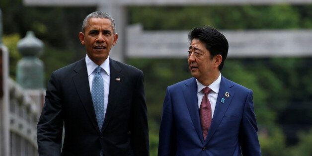U.S. President Barack Obama (R) puts his arm around Japanese Prime Minister Shinzo Abe after they laid wreaths in front of a cenotaph as the atomic bomb dome is background at Hiroshima Peace Memorial Park in Hiroshima, Japan May 27, 2016. REUTERS/Kimimasa Mayama/Pool