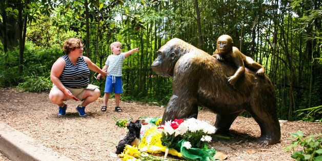 A mother and her child visit a bronze statue of a gorilla outside the Cincinnati Zoo's Gorilla World exhibit, two days after a boy tumbled into its moat and officials were forced to kill Harambe, a Western lowland gorilla, in Cincinnati, Ohio, U.S. May 30, 2016.  REUTERS/William Philpott