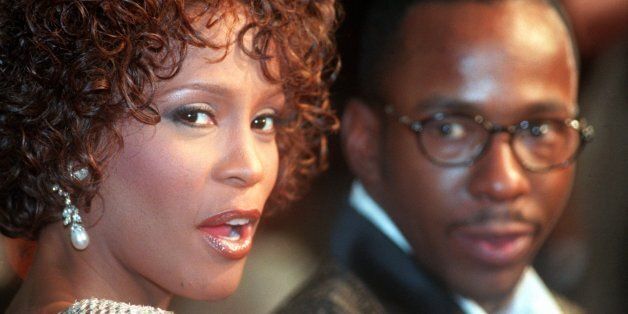 Whitney Houston looks over her shoulder as her husband Bobbi Brown looks to her at the premiere of