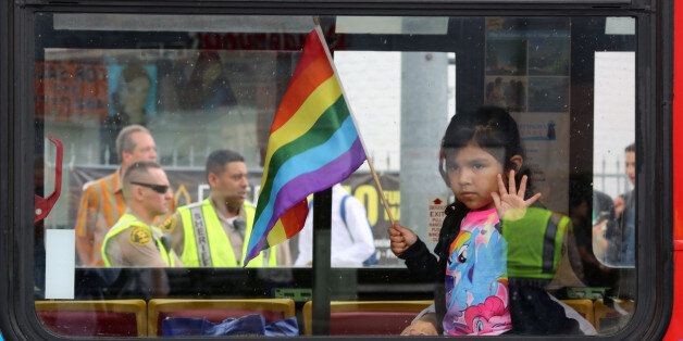Los Angeles County Sheriff's deputies are seen behind a girl riding in a bus at the 46th annual Los Angeles Gay Pride Parade in West Hollywood, California, after a gunman opened fire at a gay nightclub in Orlando, Florida U.S. June 12, 2016.  REUTERS/David McNew