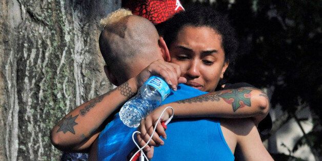 Friends and family members embrace outside the Orlando Police Headquarters during the investigation of a shooting at the Pulse nightclub, where people were killed by a gunman, in Orlando, Florida, U.S June 12, 2016.  REUTERS/Steve Nesius