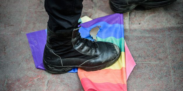 A Turkish anti-riot police officer steps on a rainbow flag during a rally staged by the LGBT community on Istiklal avenue in Istanbul on June 19, 2016.Turkish riot police fired rubber bullets and tear gas to break up a rally staged by the LGBT community in Istanbul on June 19 in defiance of a ban. Several hundred police surrounded the main Taksim Square -- where all demonstrations have been banned since 2013 -- to prevent the 'Trans Pride' event taking place during Ramadan. / AFP / OZAN KOSE