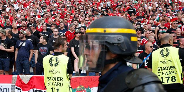 A French riot police officer walks past the Hungarian fans sector prior to the Euro 2016 Group F soccer match between Iceland and Hungary at the Velodrome stadium in Marseille, France, Saturday, June 18, 2016. Hungarian fans have clashed with stewards ahead of their team's game against Iceland at the European Championship. (AP Photo/Ariel Schalit)
