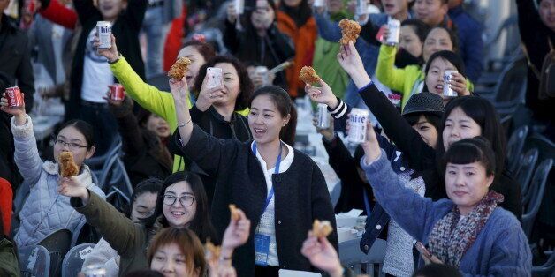 Chinese tourists make a toast with canned drinks and fried chicken pieces during an event organized by a Chinese company at a park in Incheon, South Korea, March 28, 2016. REUTERS/Kim Hong-Ji