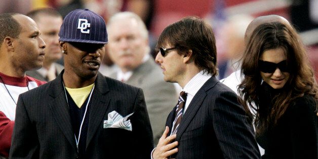Actors Jamie Foxx (L), Tom Cruise (C) and Katie Holmes talk on the Washington Redskins sidelines before the Monday Night Football game against the Minnesota Vikings in Landover, Maryland September 11, 2006.     REUTERS/Gary Cameron  (UNITED STATES)