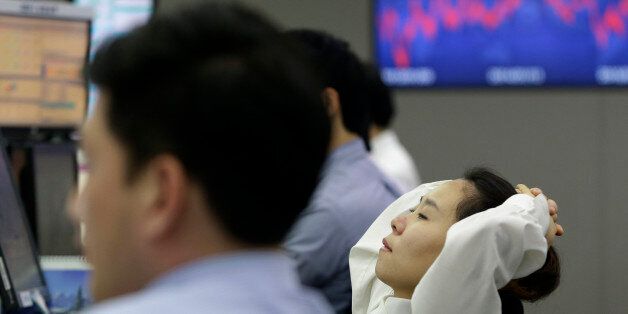 A currency trader watches her monitors at the Korea Exchange Bank headquarters in Seoul, South Korea, Friday, Jan. 16, 2015. Asian stocks were sharply lower Friday after a surprise move by the Swiss National Bank to abandon its efforts to keep its currency artificially cheap shocked the market. South Korea's Kospi fell 1.4 percent to 1,887.10. (AP Photo/Ahn Young-joon)