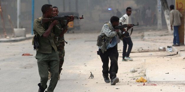 Somali government soldiers run to take their positions during gunfire after a suicide bomb attack outside Nasahablood hotel in Somalia's capital Mogadishu, June 25, 2016. REUTERS/Feisal Omar