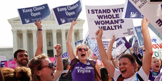 Demonstrators celebrate at the U.S. Supreme Court after the court struck down a Texas law imposing strict regulations on abortion doctors and facilities that its critics contended were specifically designed to shut down clinics in Washington June 27, 2016. REUTERS/Kevin Lamarque     TPX IMAGES OF THE DAY