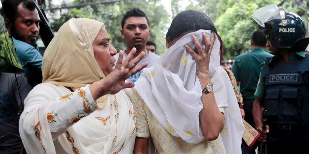 A relative tries to console Semin Rahman, covering face, whose son is missing after militants took hostages in a restaurant popular with foreigners in Dhaka, Bangladesh, Saturday, July 2, 2016. Bangladeshi forces stormed the Holey Artisan Bakery in Dhaka's Gulshan area where heavily armed militants held dozens of people hostage Saturday morning, rescuing some captives including foreigners at the end of the 10-hour standoff. (AP Photo)