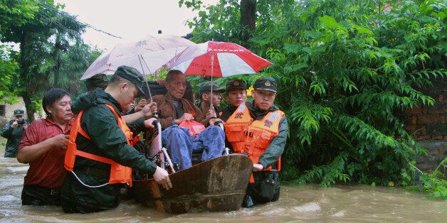 Rescuers save a resident from a flooded area in Anqing, Anhui Province, China, July 2, 2016. REUTERS/Stringer ATTENTION EDITORS - THIS IMAGE WAS PROVIDED BY A THIRD PARTY. EDITORIAL USE ONLY. CHINA OUT. NO COMMERCIAL OR EDITORIAL SALES IN CHINA.  THIS PICTURE WAS PROCESSED BY REUTERS TO ENHANCE QUALITY. AN UNPROCESSED VERSION HAS BEEN PROVIDED SEPARATELY.