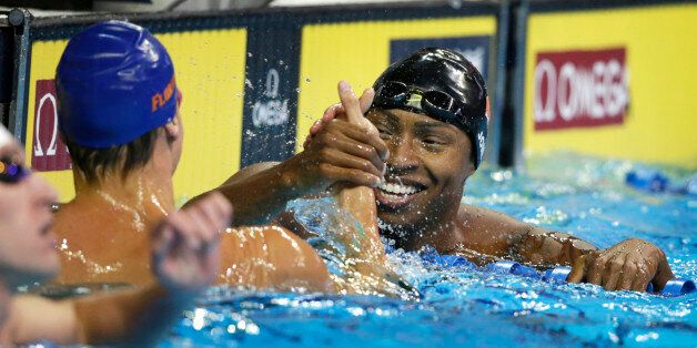 Cullen Jones, right, reacts with Caeleb Dressel, left, after their heat in the men's 50-meter freestyle preliminaries at the U.S. Olympic swimming trials, in Omaha, Neb., Friday, July 1, 2016. (AP Photo/Nati Harnik)