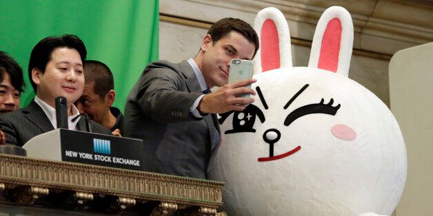 New York Stock Exchange President Tom Farley, center, takes a selfie with Line character Cony on the bell podium at the NYSE, Thursday, July 14, 2016. Line Chief Strategy & Marketing Officer Jun Masuda is at left, before his company's IFO.
