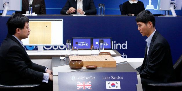 South Korean professional Go player Lee Sedol, right, prepares for his first stone against Google's artificial intelligence program, AlphaGo, as Google DeepMind's lead programmer Aja Huang, left, sits during the second match of the Google DeepMind Challenge Match in Seoul, South Korea, Thursday, March 10, 2016. Google's computer program AlphaGo defeated its human opponent, South Korean Go champion Lee Sedol, on Wednesday in the first face-off of a historic five-game match. (AP Photo/Lee Jin-man)