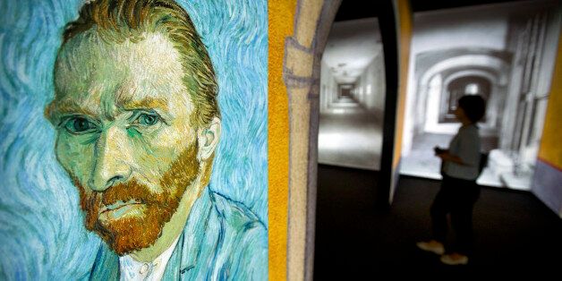 A visitor walks past an image of Van Gogh's