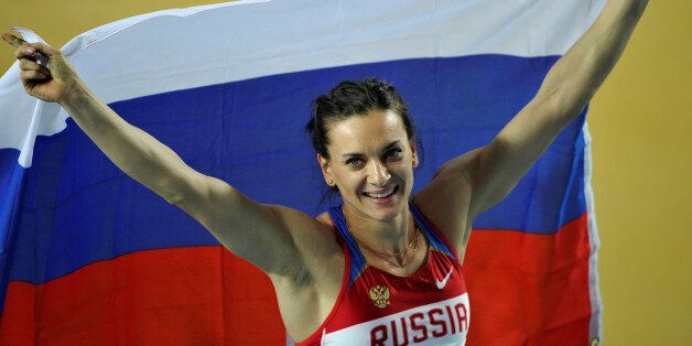 Gold medalist Elena Isinbayeva of Russia holds her national flag after the women's pole vault final during the world indoor athletics championships at the Atakoy Athletics Arena in Istanbul March 11, 2012. Isinbayeva won the gold medal with 4,80 metres, ahead of Bosiak who won silver and Bleasdale who won bronze. REUTERS/Dylan Martinez/File Photo