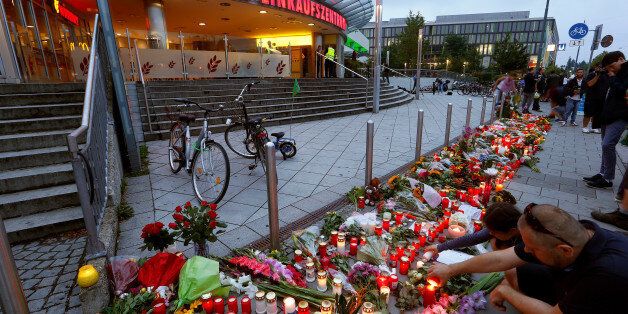 People light candles beside flowers laid in front of the Olympia shopping mall, where yesterday's shooting rampage started, in Munich, Germany July 23, 2016. REUTERS/Arnd Wiegmann