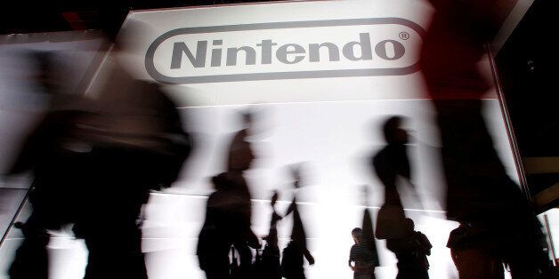 Attendees walk past the Nintendo of America Inc. booth during the Electronic Entertainment Expo or E3 in Los Angeles June 7, 2011. REUTERS/Danny Moloshok/File Photo