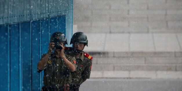 North Korean soldiers keeps watch toward the south as it rains during a ceremony marking the 63rd anniversary of the signing of the Korean War ceasefire armistice agreement at the truce village of Panmunjom, South Korea, July 27, 2016.  REUTERS/Kim Hong-Ji