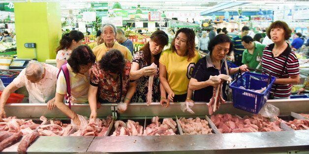 Customers select meat at a supermarket in Hangzhou, Zhejiang province, China, June 9, 2016. REUTERS/Stringer ATTENTION EDITORS - THIS PICTURE WAS PROVIDED BY A THIRD PARTY. EDITORIAL USE ONLY. CHINA OUT. NO COMMERCIAL OR EDITORIAL SALES IN CHINA.