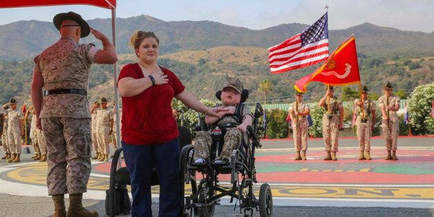 Wyatt Gillette, 8, front right, visits Camp Pendleton, Calif., Saturday, July 30, 2016, with his mother Felicia, front center, as his father, Marine Staff Sgt. Jeremiah Gillette salutes during a ceremony where the young Gillette received an award to become an honorary Marine. Gillette, who had the genetic disease  Aicardi-Goutieres syndrome, which causes seizures and kidney failure, died Sunday, July 31, 2016. (Lance Cpl. Angelica Annastas/U.S. Marine Corps via AP)