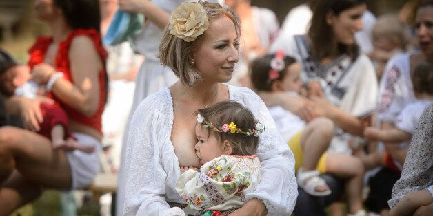 A woman breastfeeds her eighteen-month-old daughter Anastasia at an event promoting the freedom of mothers to breastfeed in public, during World Breastfeeding Week at the Village Museum in Bucharest, Romania, Saturday, Aug. 6, 2016. (AP Photo/Andreea Alexandru)