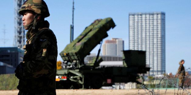 FILE PHOTO - Members of the Japan Self-Defence Forces stand guard near Patriot Advanced Capability-3 (PAC-3) land-to-air missiles, deployed at the Defense Ministry in Tokyo December 7, 2012.  REUTERS/Issei Kato/File Photo