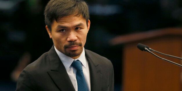 Filipino boxer and now Senator Manny Pacquiao listens to an interpellation by a fellow senator shortly after delivering his
