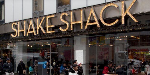 FILE - In this Friday, March 4, 2016, file photo, people walk past a Shake Shack in New York. Shake Shack reports financial results Thursday, May 12, 2016. (AP Photo/Mark Lennihan, File)