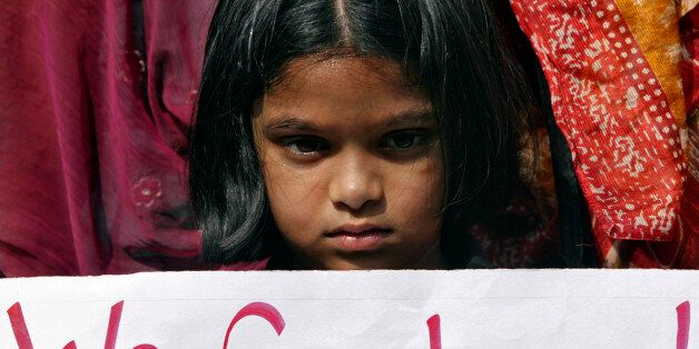 A girl holds a placard as she takes part in a protest rally in the southern Indian city of Hyderabad December 29, 2012. A woman whose gang rape sparked protests and a national debate about violence against women in India died of her injuries on Saturday, prompting a security lockdown in New Delhi and an acknowledgement from India's prime minister that social change is needed. REUTERS/Krishnendu Halder (INDIA - Tags: CRIME LAW CIVIL UNREST)