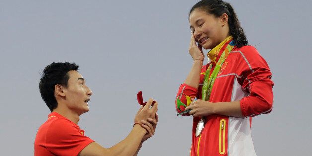 China's diver Qin Kai, left, proposes to silver medalist He Zhi of the women's 3-meter springboard diving finals in the Maria Lenk Aquatic Center at the 2016 Summer Olympics in Rio de Janeiro, Brazil, Sunday, Aug. 14, 2016. (AP Photo/Wong Maye-E)