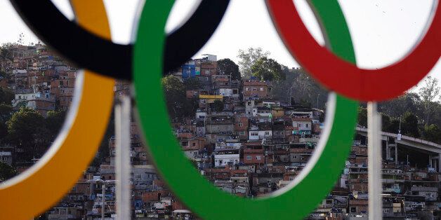 Houses from a favela are photographed through the Olympic rings prior to the opening ceremony for the 2016 Summer Olympics in Rio de Janeiro, Brazil, Friday, Aug. 5, 2016. (AP Photo/Jae C. Hong)