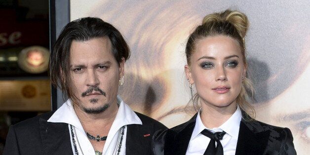 Cast member Amber Heard and husband Johnny Depp pose during the premiere of the film