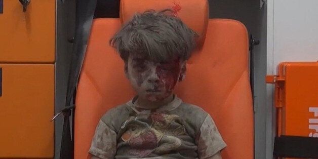 FILE - In this frame grab taken from video provided by the Syrian anti-government activist group Aleppo Media Center (AMC), 5-year-old Omran Daqneesh sits in an ambulance after being pulled out or a building hit by an airstirke, in Aleppo, Syria, Wednesday, Aug. 17, 2016. The White Helmets, were among the crowd of first responders who pulled Daqneesh and his family from the rubble of their apartment building Wednesday night.  (Aleppo Media Center via AP)