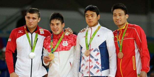 Medal winners in the men's 90 kg judo competition of the 2016 Summer Olympics stand on the podium in Rio de Janeiro, Brazil, Wednesday, Aug. 10, 2016. They are, from left, silver medal winner Varlam Liparteliani of Georgia, gold medal winner Mashu Baker of Japan, and bronze medalists Gwak Dong-han of South Korea and Cheng Xunzhao of China. (AP Photo/Gregory Bull)