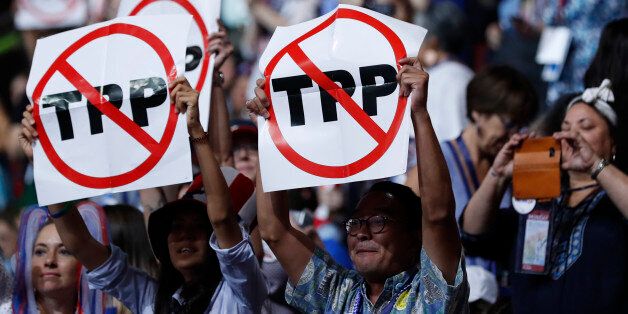 Delegates protesting against the Trans Pacific Partnership (TPP) trade agreement hold up signs during the first sesssion of the Democratic National Convention in Philadelphia, Pennsylvania, U.S. July 25, 2016. REUTERS/Mark Kauzlarich