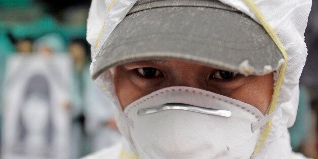 In this photo taken on March 25, 2010, a South Korean activist, wearing protective clothing, participates during a rally near the Samsung semiconductor factory in Yongin, south of Seoul, South Korea. Samsung Electronics said Thursday, April 15, 2010, workers at its semiconductor factories face no heightened cancer risk as the world's top maker of memory chips tried to quell health fears following employee illnesses and deaths. (AP Photo/ Lee Jin-man)